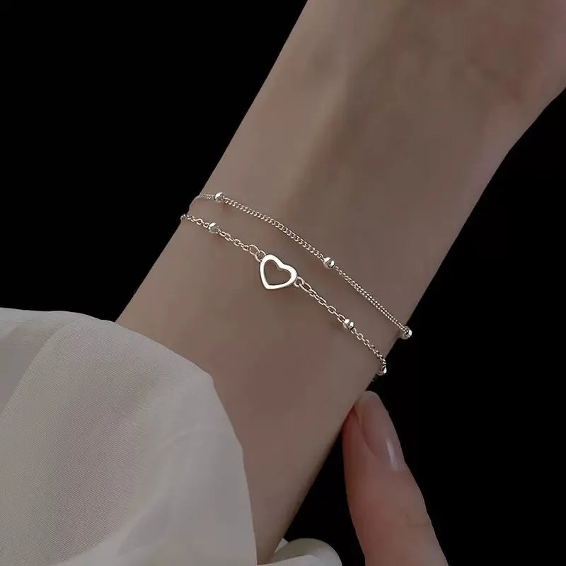 Pulseira Dupla Coração Vazado: Brilho Prateado Minimalista