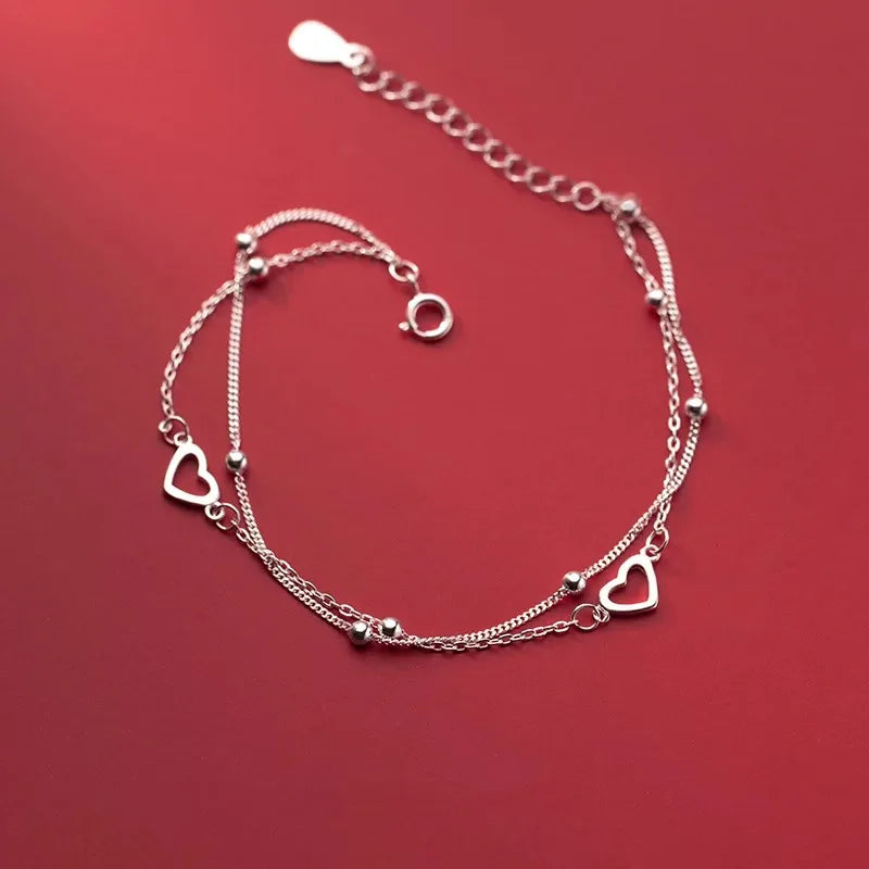 Pulseira Dupla Coração Vazado: Brilho Prateado Minimalista