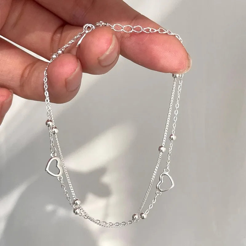 Pulseira Dupla Coração Vazado: Brilho Prateado Minimalista