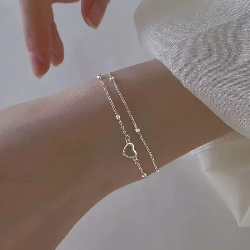Pulseira Dupla Coração Vazado: Brilho Prateado Minimalista