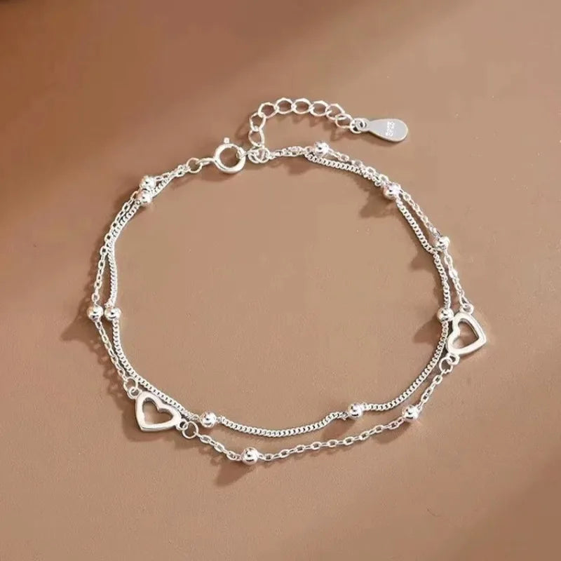 Pulseira Dupla Coração Vazado: Brilho Prateado Minimalista